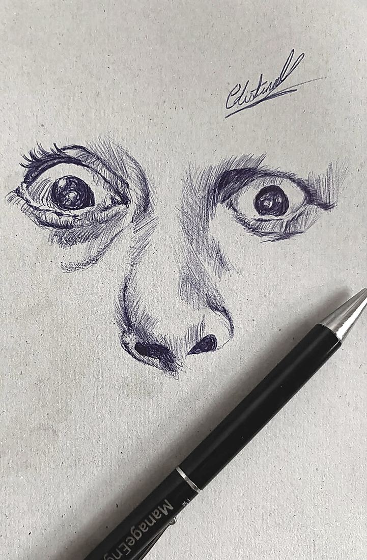 Papel gris. Los ojos y la nariz de un rostro, firmados arriba. El boligrafo negro cruza el papel en diagonal.