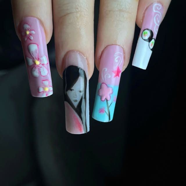 Coleccion Sakura. Unas largas y cuadradas: una rosa con flores en relieve, otra negra con una mujer de perfil de estilo japones, otra celeste con una flor de cerezo y una blanca con un circulo negro.