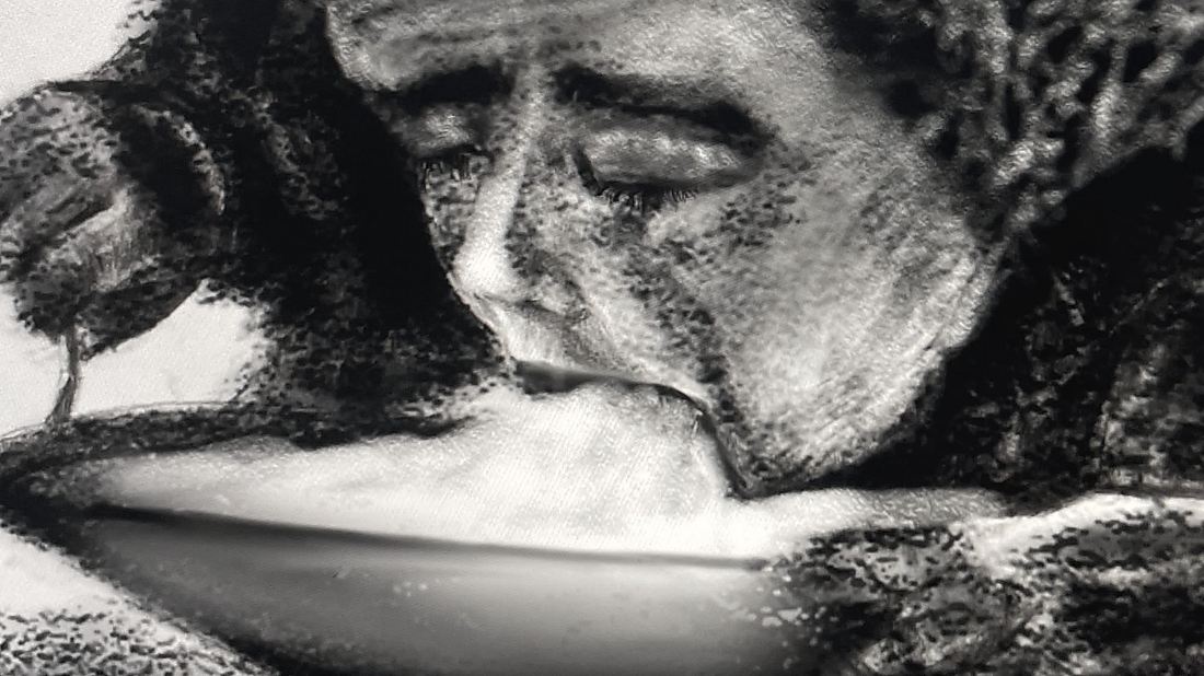 Carboncillo apaisado en blanco y negro. Un rostro de perfil, inclinado hacia abajo con la boca abierta sobre una superficie curva, saliendo a medias de un fondo negro y espeso.